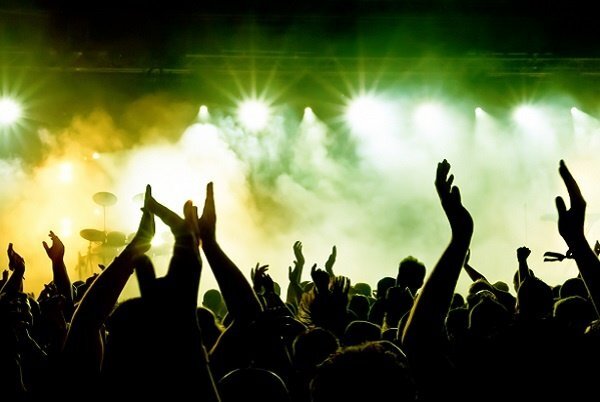 A live concert with green and yellow lights.