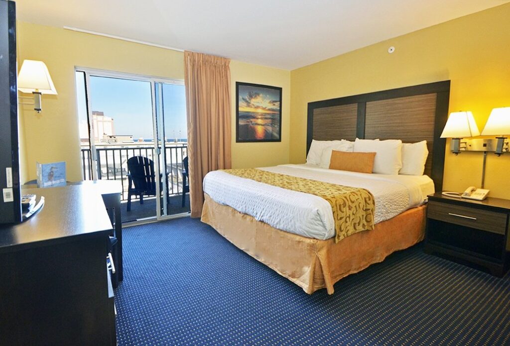 a hotel room with a bed, desk and television