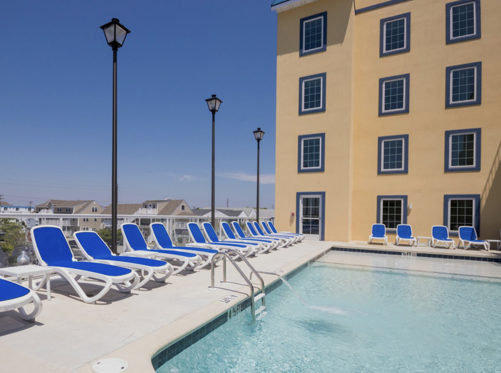 a row of lawn chairs next to a swimming pool