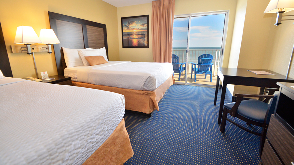 a hotel room with two beds and a balcony