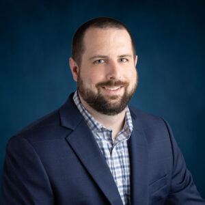 a man with a beard wearing a blue suit