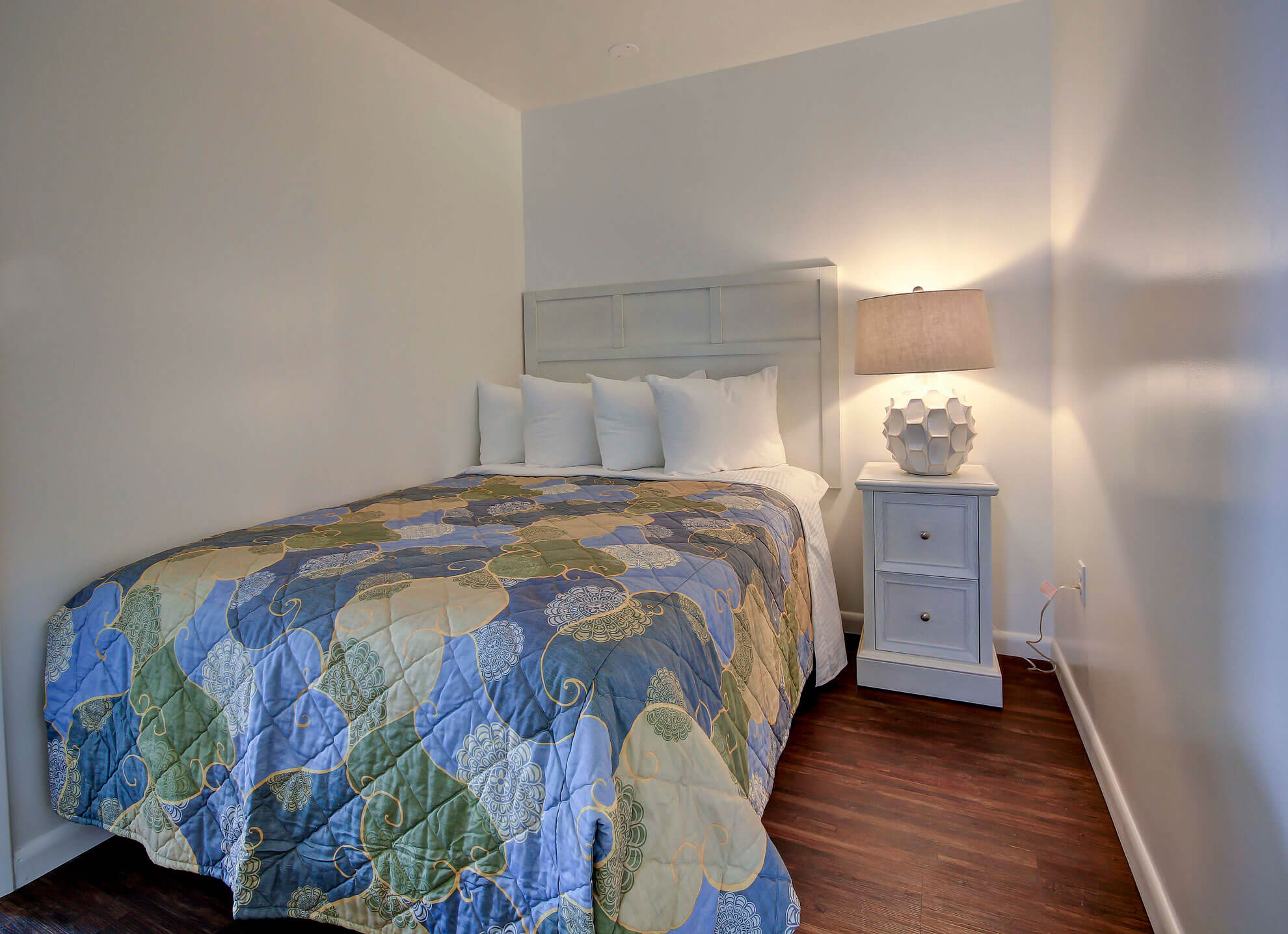 a bed sitting in a bedroom next to a window