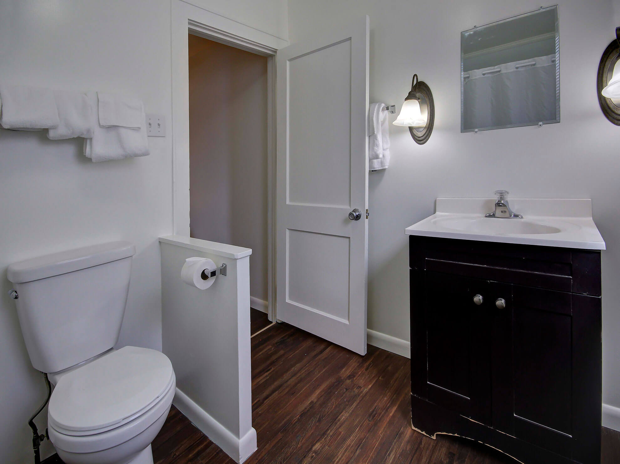 a bathroom with a toilet, sink, and mirror