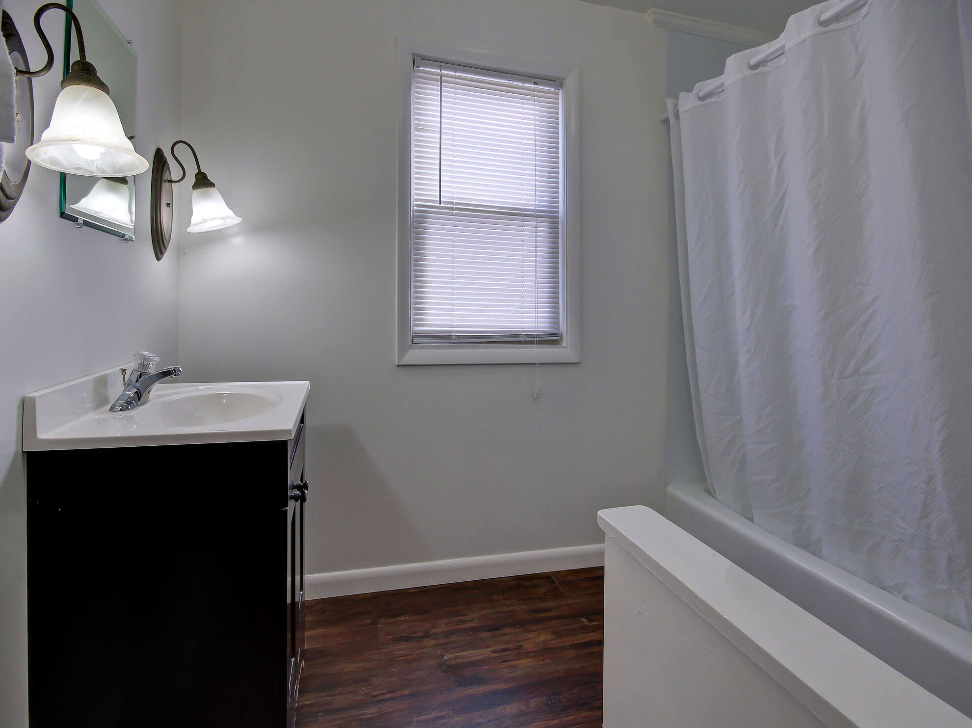 a bathroom with a sink, mirror, and bathtub