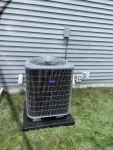 a air conditioner sitting in the grass next to a building