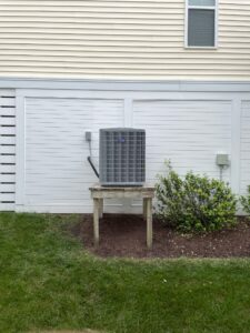 a air conditioner sitting on top of a wooden bench