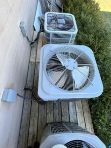 a couple of air conditioners sitting on top of a wooden deck