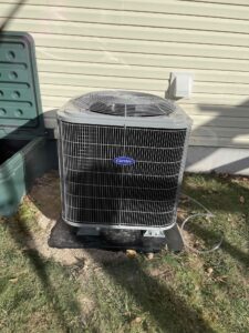 an air conditioner sitting in the grass next to a building