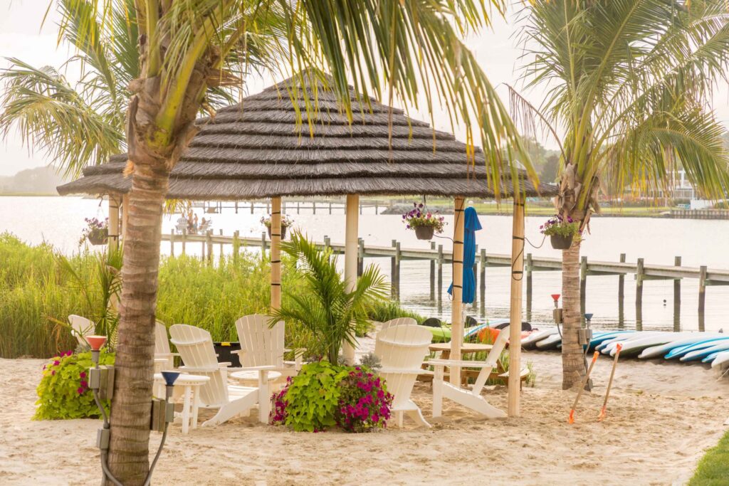 a beach area with chairs and umbrellas on the sand