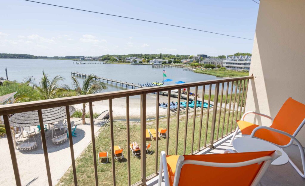 a balcony with chairs and a view of a body of water