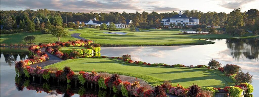 a golf course surrounded by water and trees