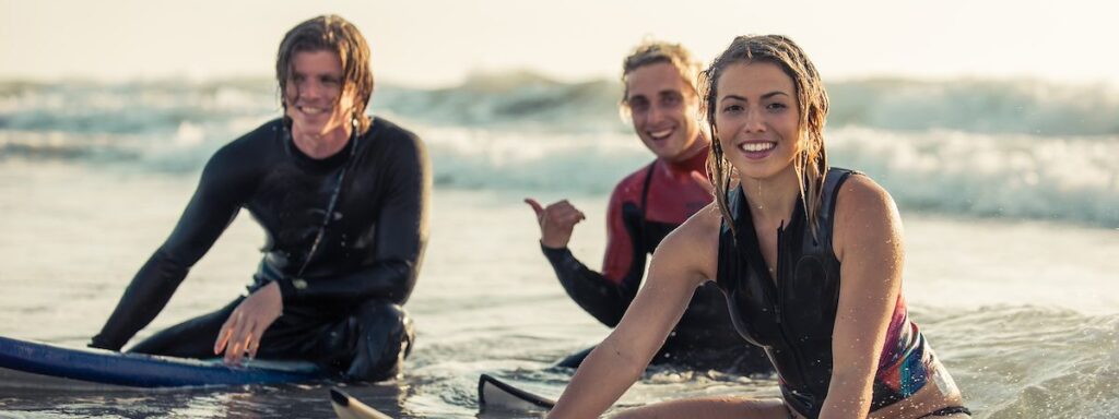 a group of people riding surfboards on top of a body of water