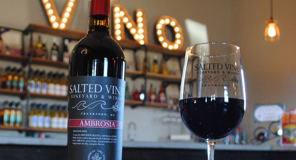 a glass of wine sitting next to a bottle of wine