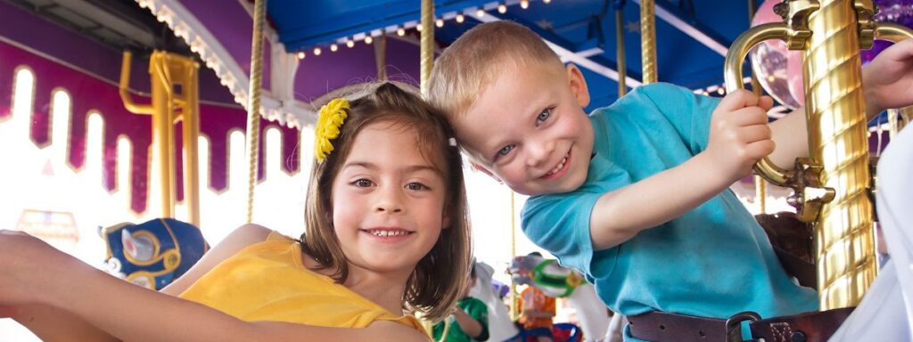 a little boy and a little girl riding a merry go round