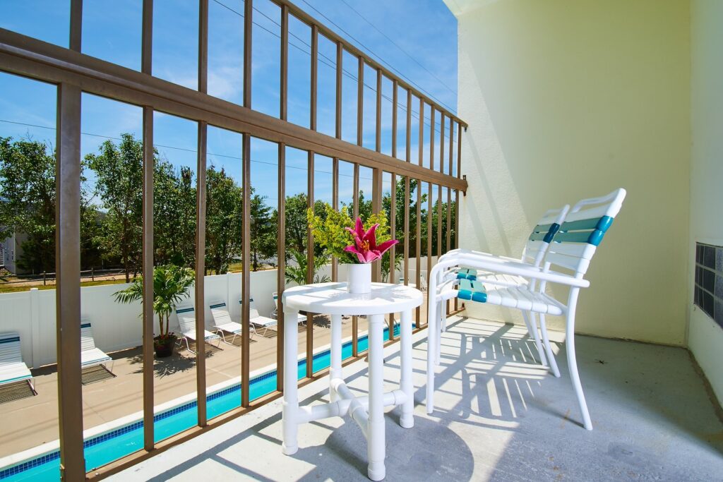 a balcony with a table and chairs next to a pool