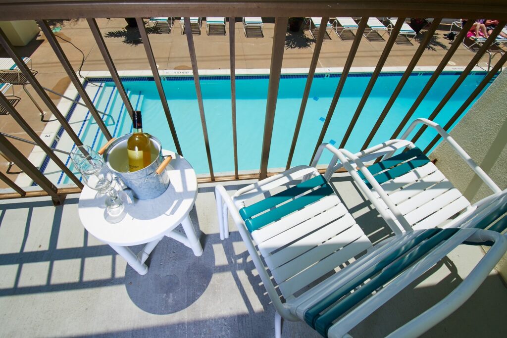 a balcony with a table and chairs next to a pool