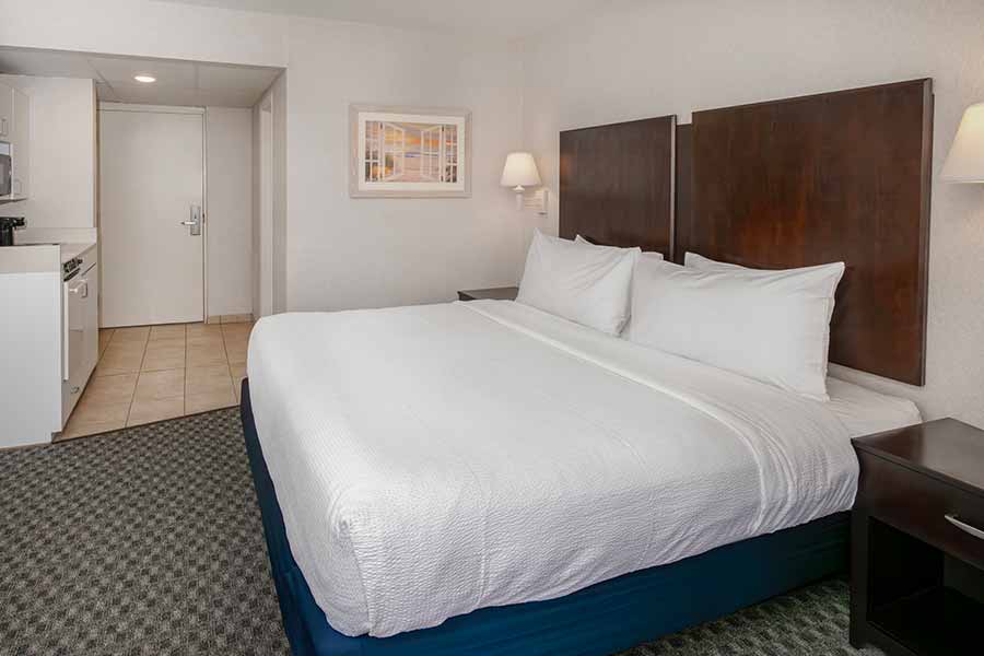 a hotel room with a bed, microwave and refrigerator