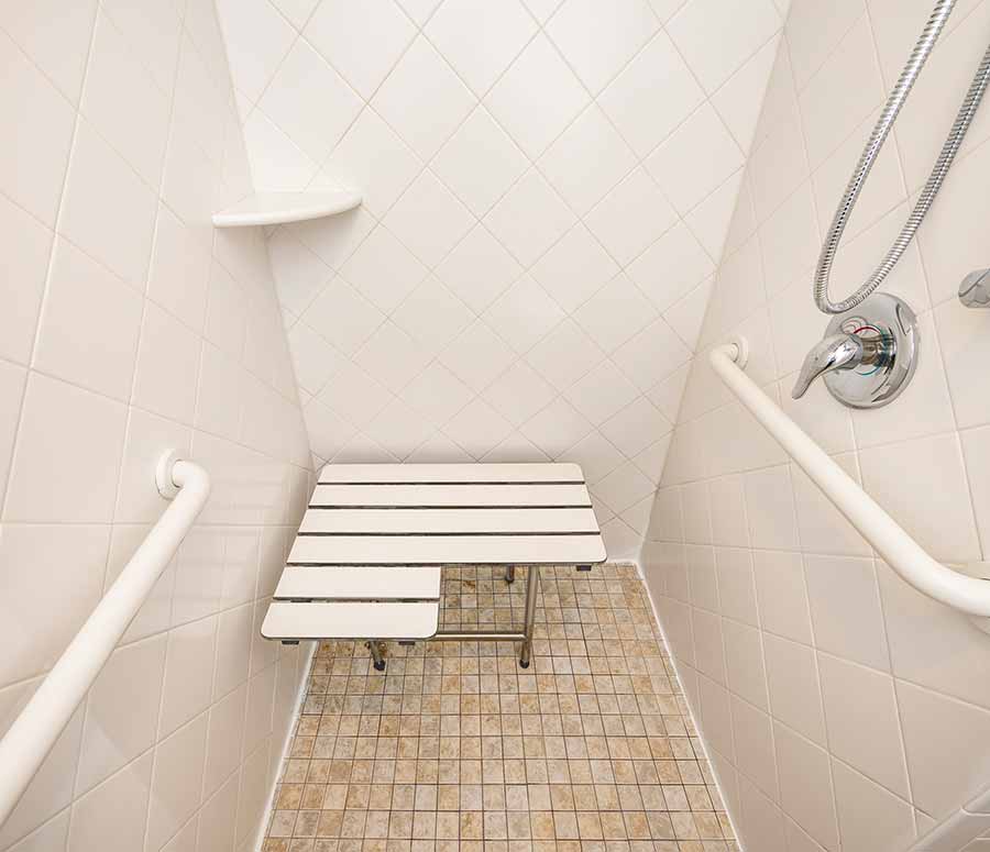 a bathroom with a bench and shower in it