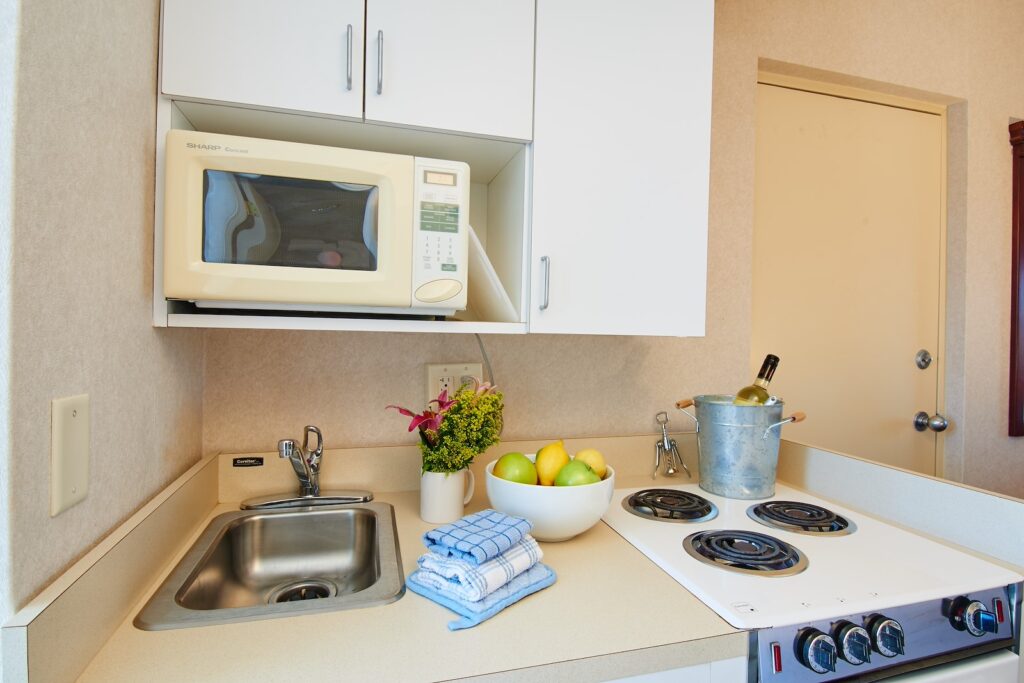 a kitchen with a sink, stove and microwave