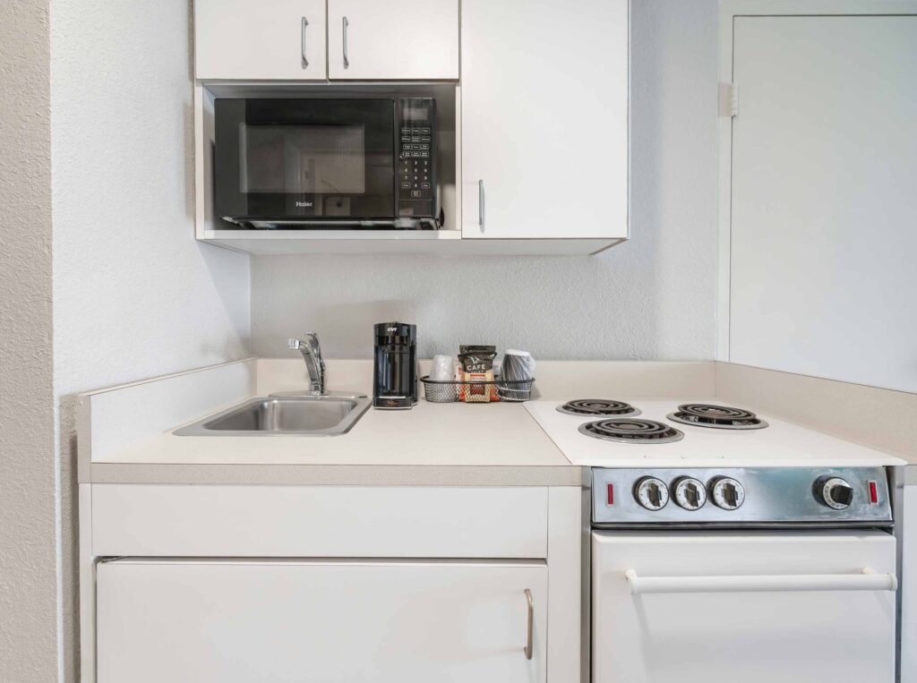 a kitchen with a stove, microwave, and cabinets