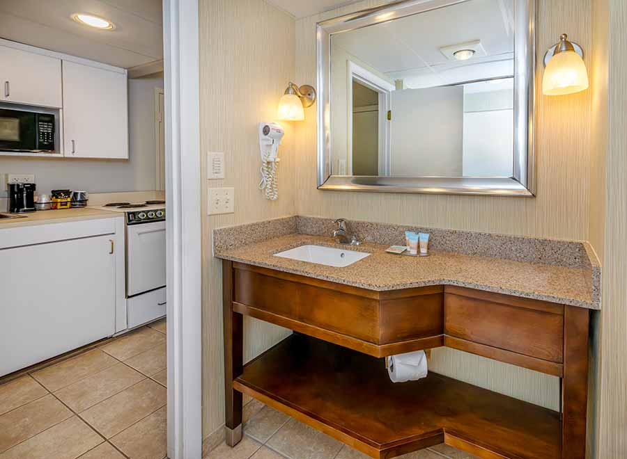 a bathroom with a sink, microwave, and washer and dryer