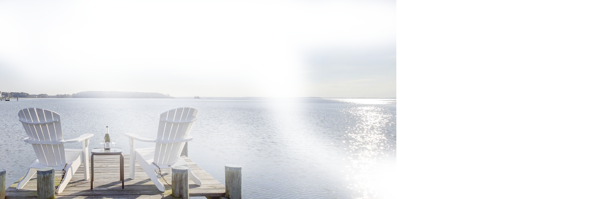 To chairs on a dock over looking the water.
