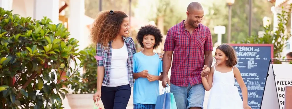 A family walking down a street with shopping bags