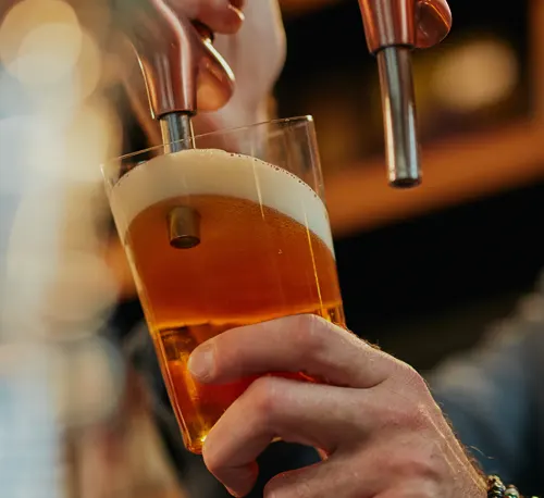 A cup being filled up with beer from the tap.
