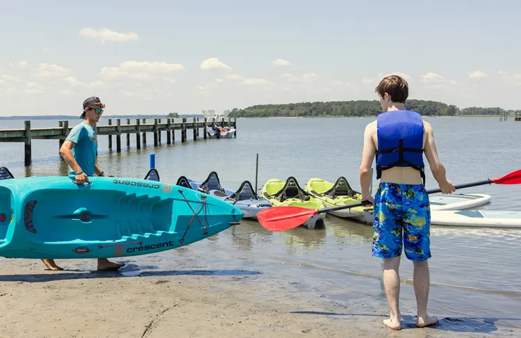 Two boys getting ready to get on a kayak
