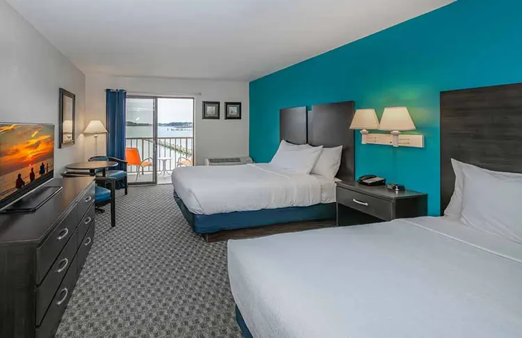 Two queen beds in a hotel room overlooking the bay.