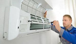 man servicing air conditioning unit