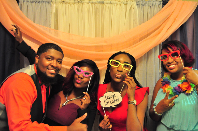 couple and friends posing with comical glasses in booth