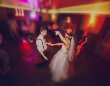 bride and groom dancing excitingly on colorfully lit dance floor