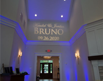 wedding couple name and date projected on wall above reception entrance doorway