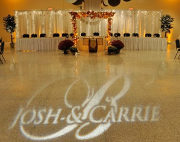 wedding couple monogram projected on dance floor in front of bridal table