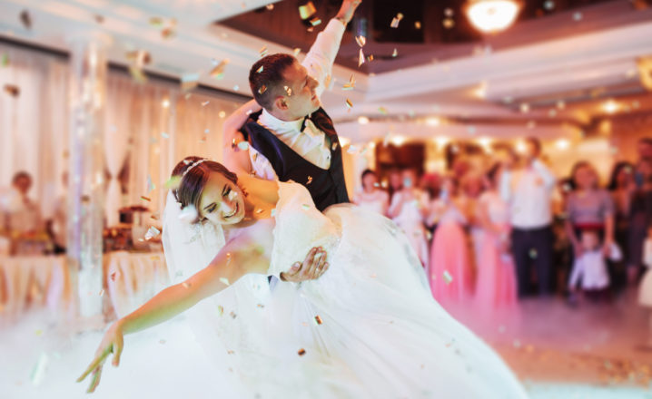 bride and groom having first dance with smoke and confetti