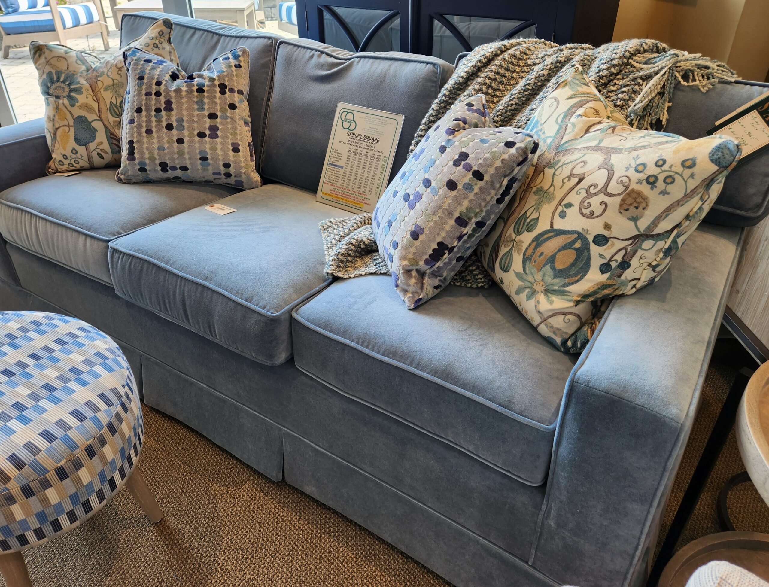 a blue couch with many pillows on it