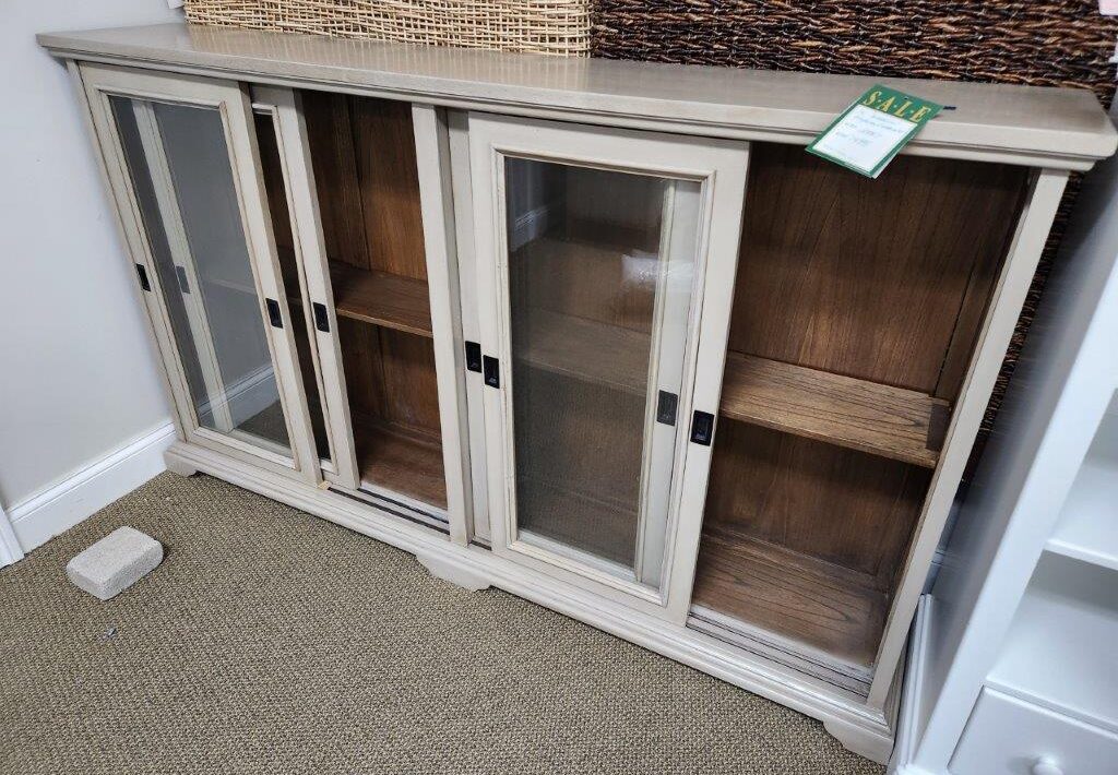a white cabinet with glass doors in a room