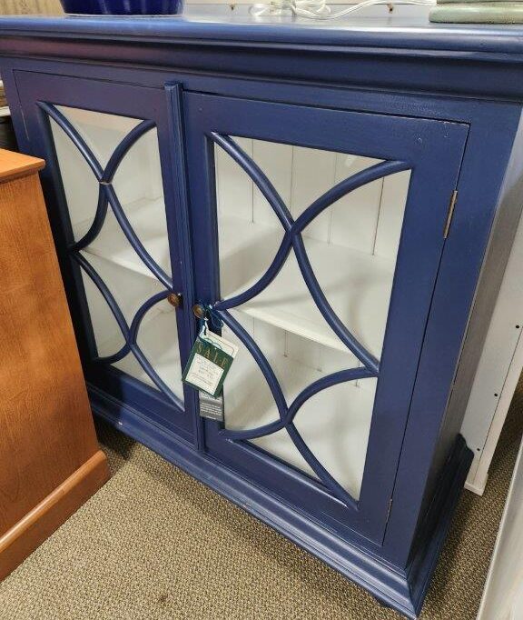 a blue china cabinet with glass doors and shelves