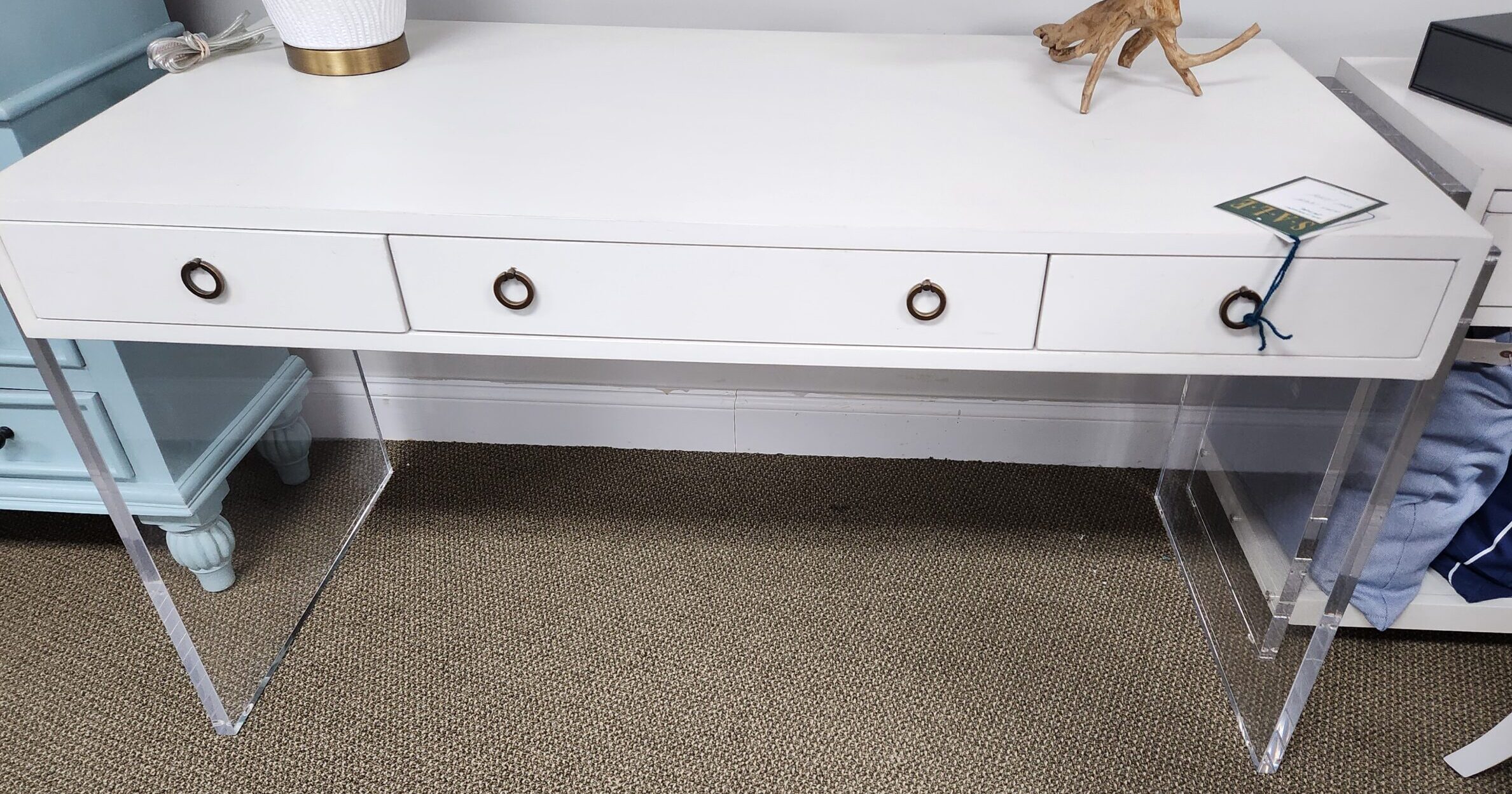 a white desk with two drawers and a monkey figurine on top