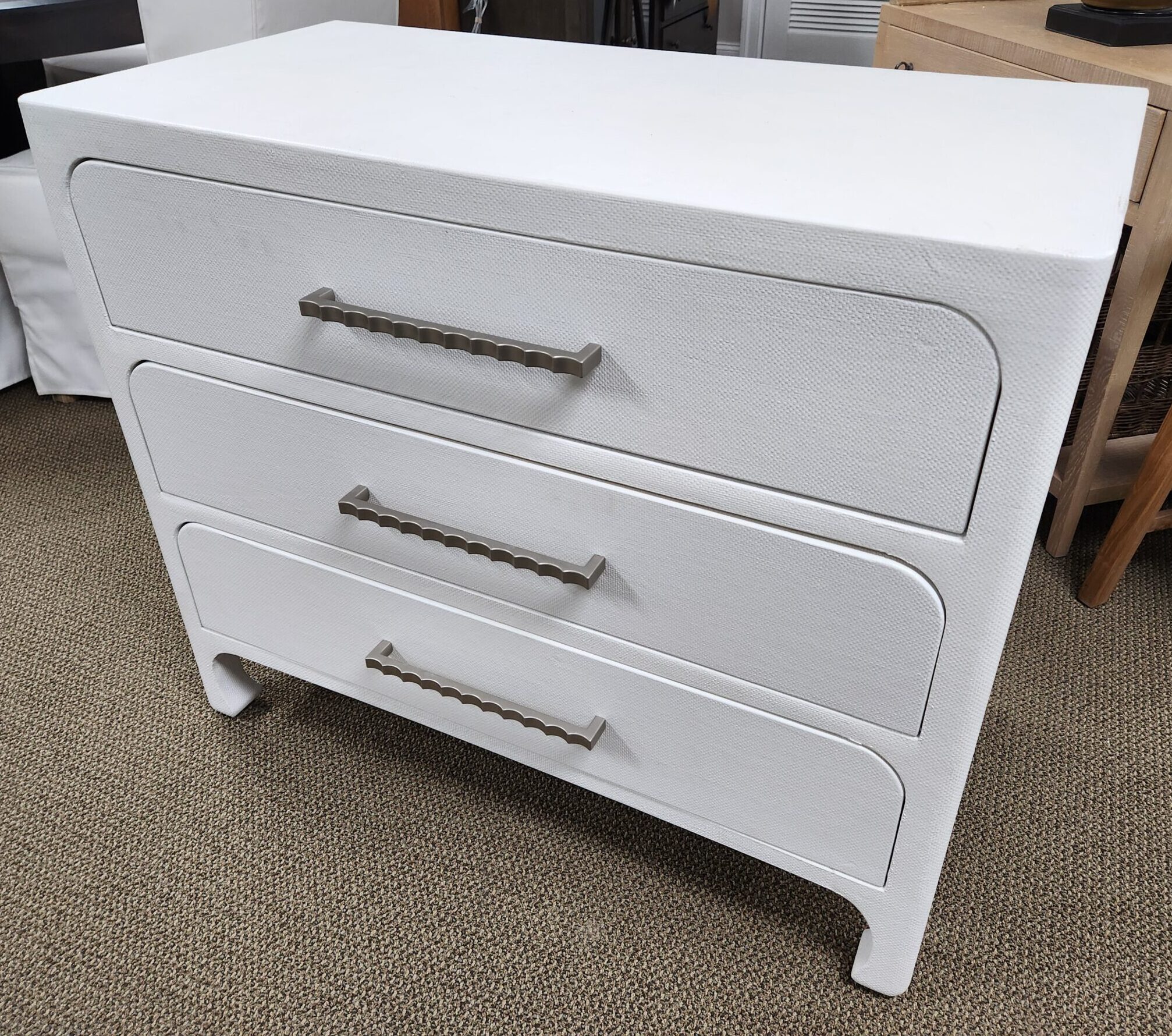 a white chest of drawers sitting on top of a carpeted floor