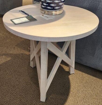 a white table with a blue vase on top of it