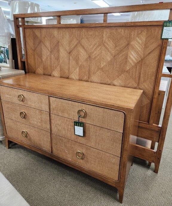 a bed with a wooden headboard and drawers