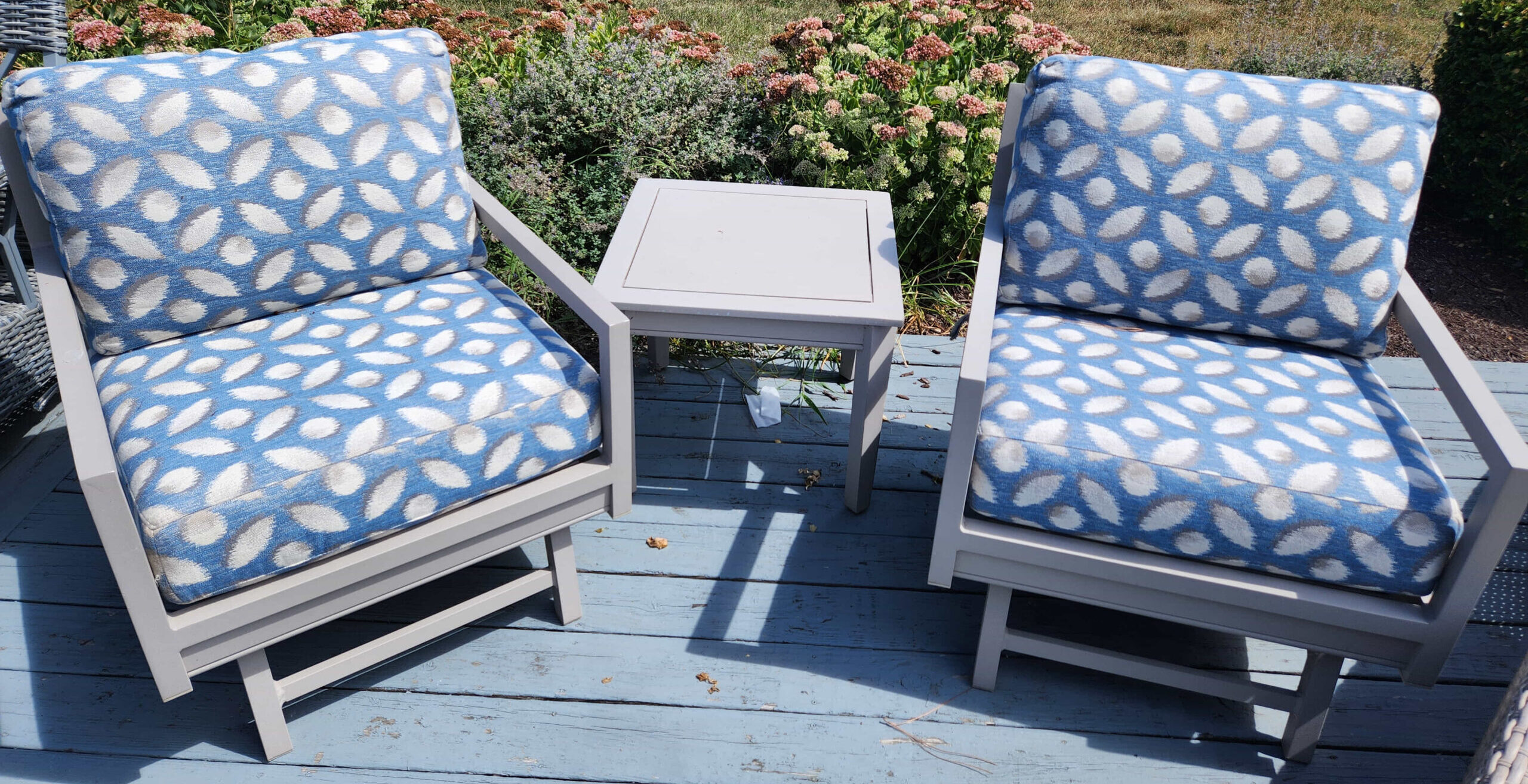 a couple of chairs sitting on top of a wooden deck