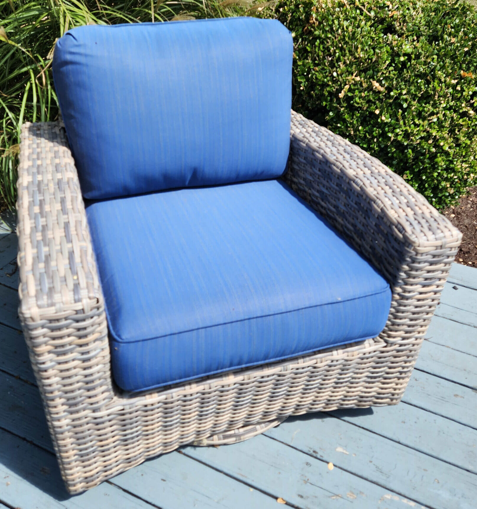 a blue couch sitting on top of a grass covered field