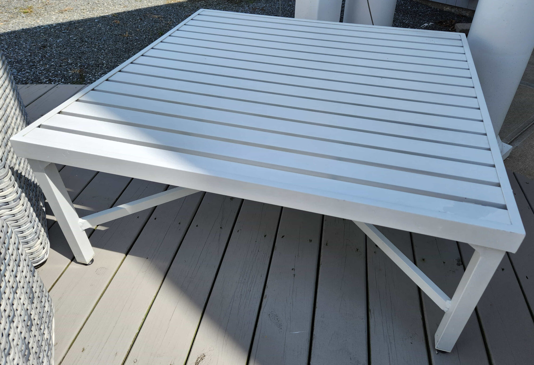 a white table sitting on top of a wooden deck