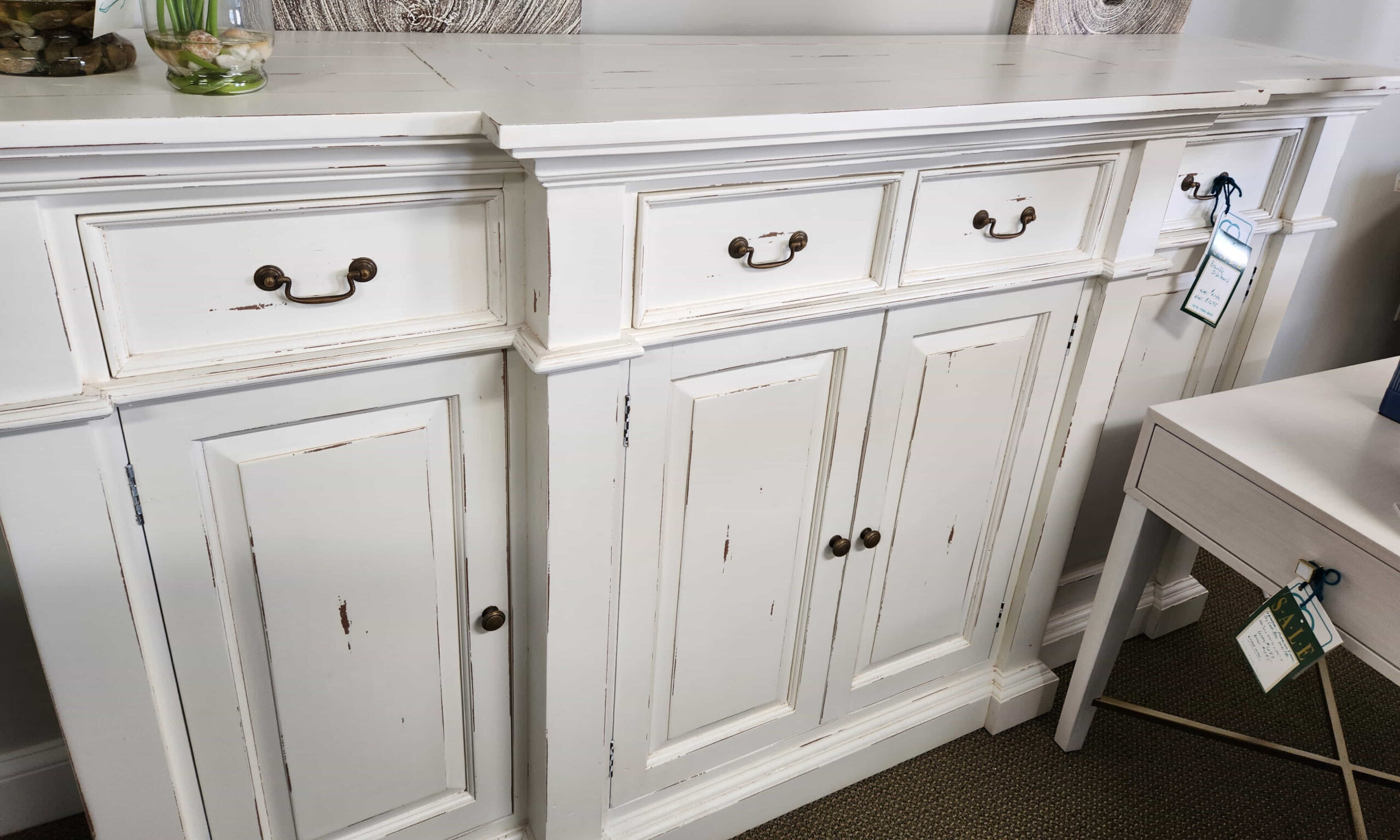 a white dresser with a bunch of flowers on top of it