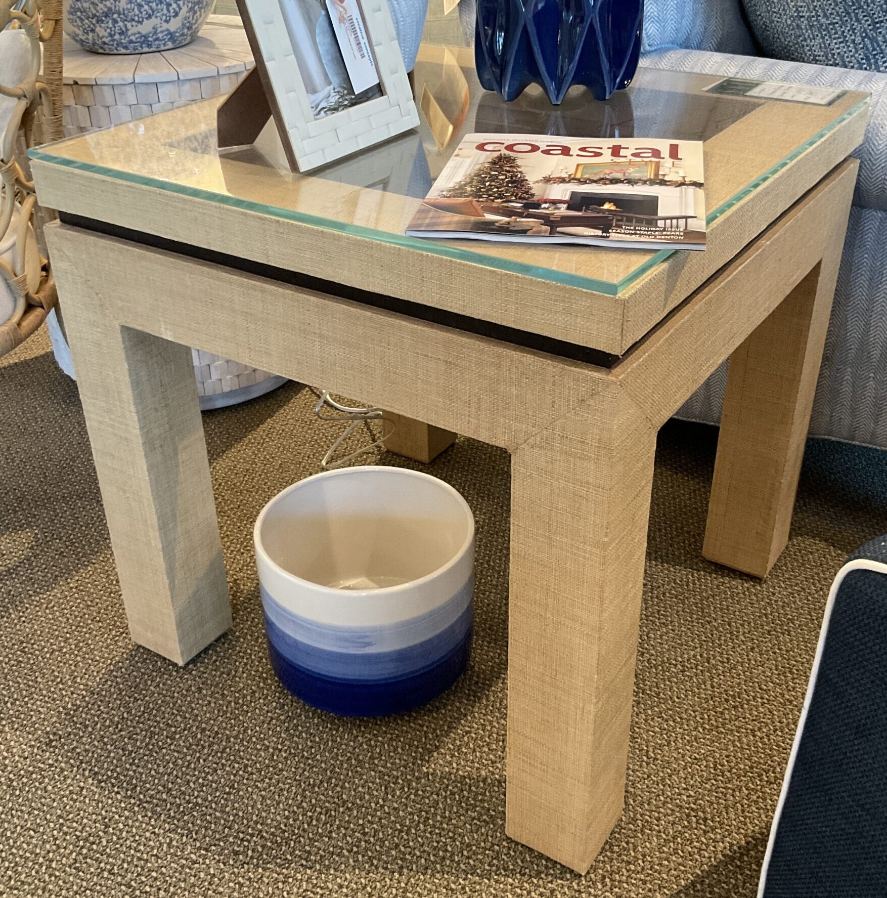 a coffee table with a blue vase on top of it