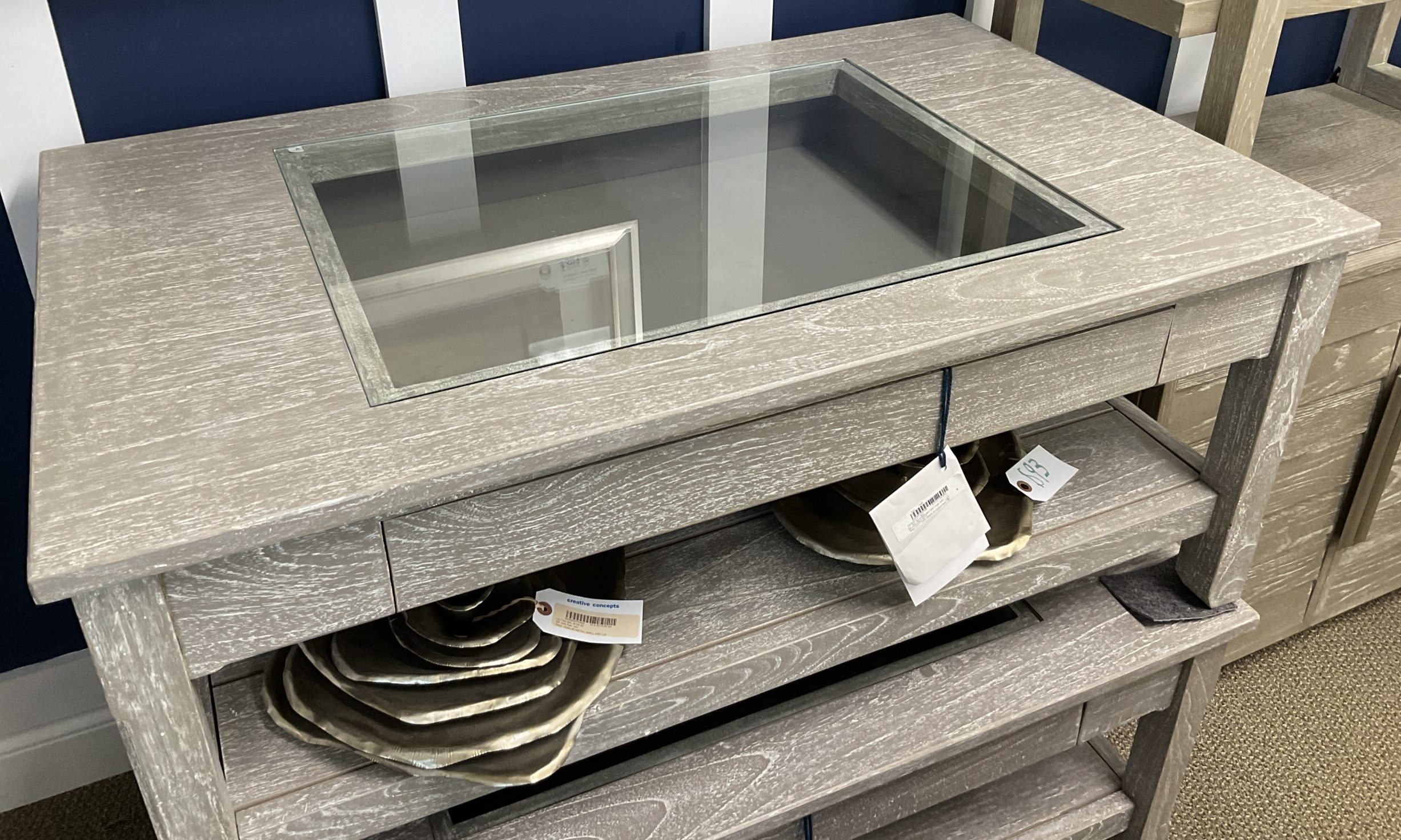 a wooden table with a glass top and drawers