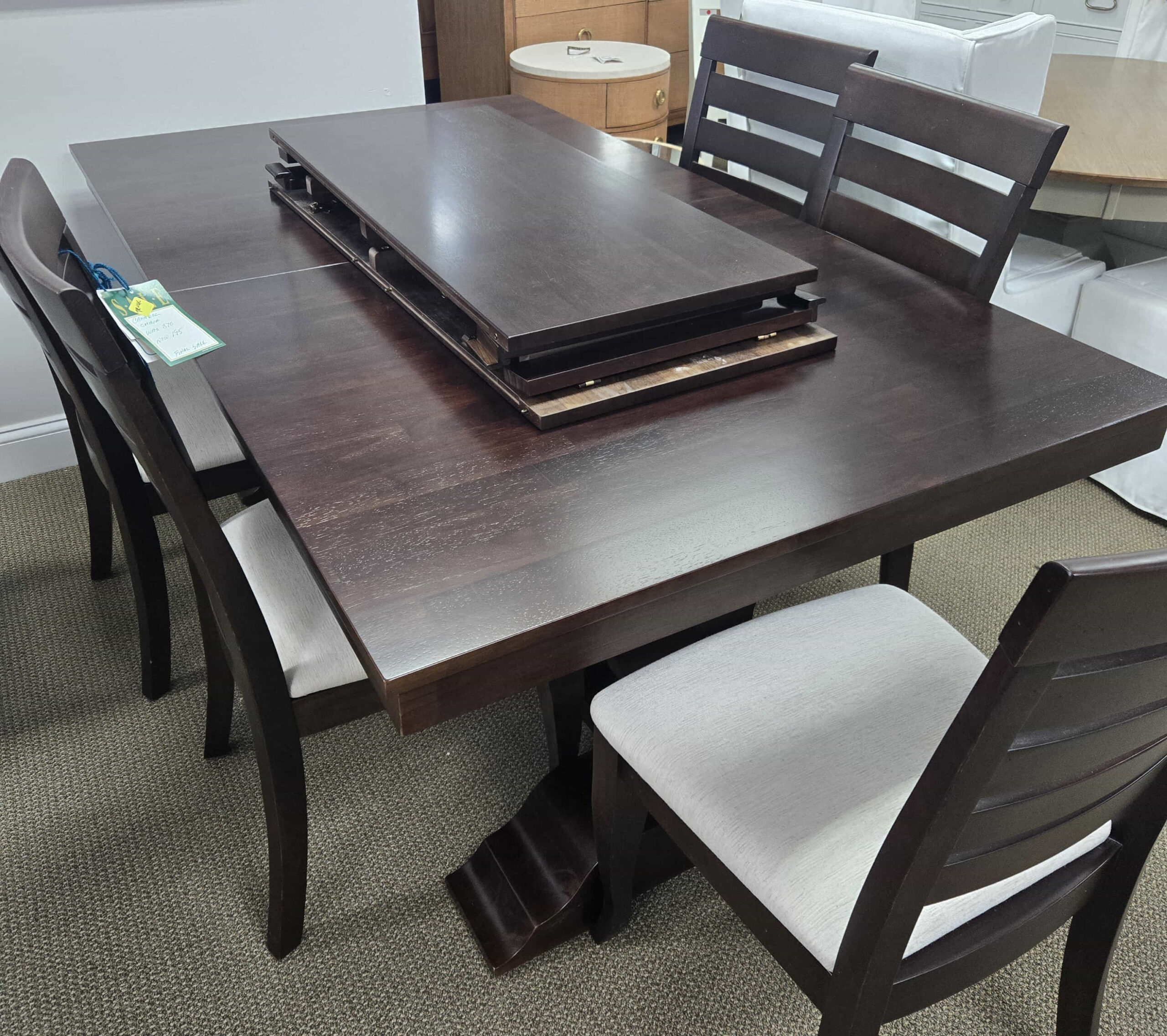a dining table with chairs and a couch in the background